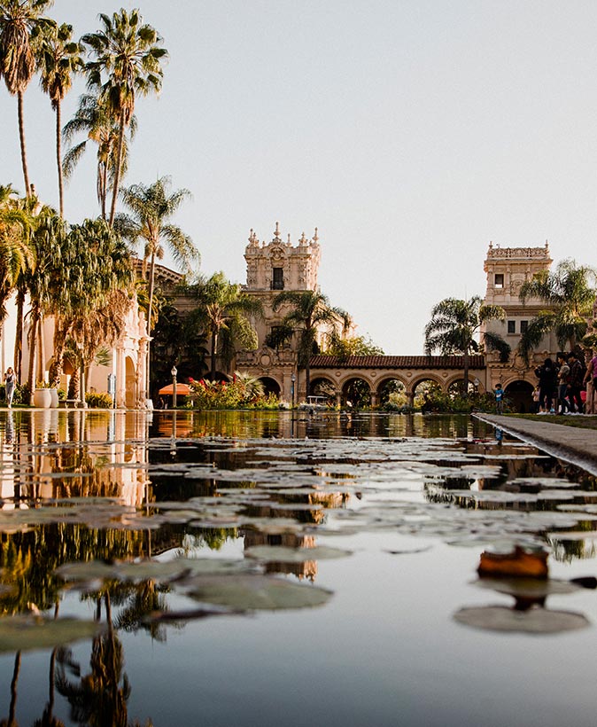 Balboa Park, a great free place to visit in San Diego a historic building with palm trees and a pond