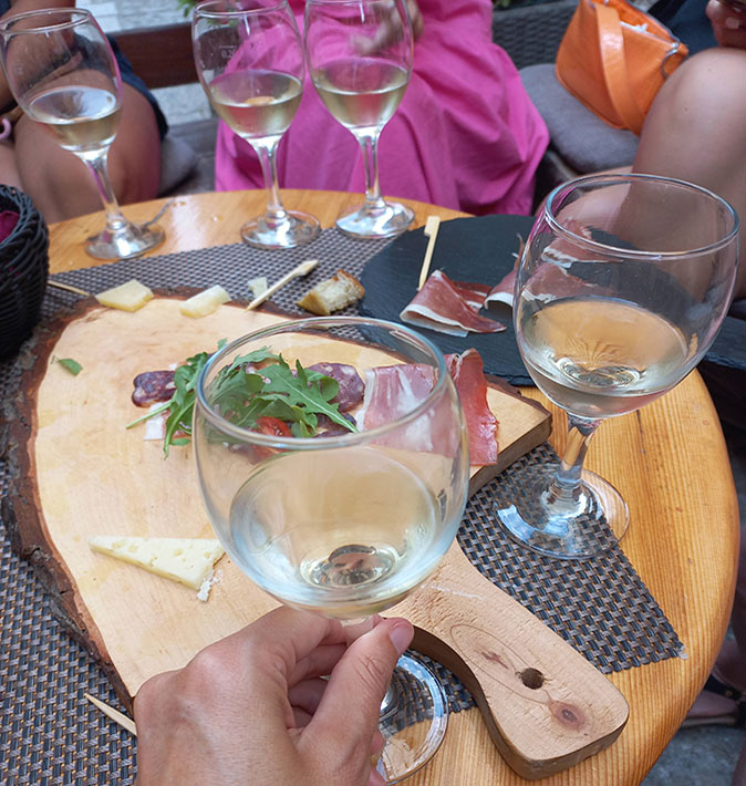 5 wine glasses and some cheese and ham on a table