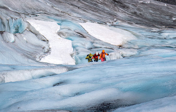 3 people ice climbing at Exit Glacier