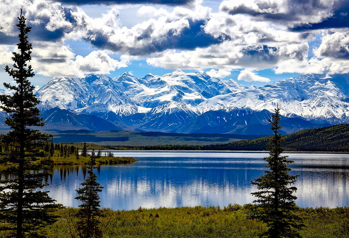 Lake with snowy mountains in the background, a highlight of an Alaska itinerary