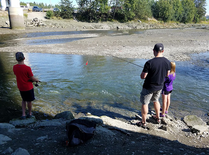 Fishing at the start of an Alaska road trip A father and two kids fishing in Alaska
