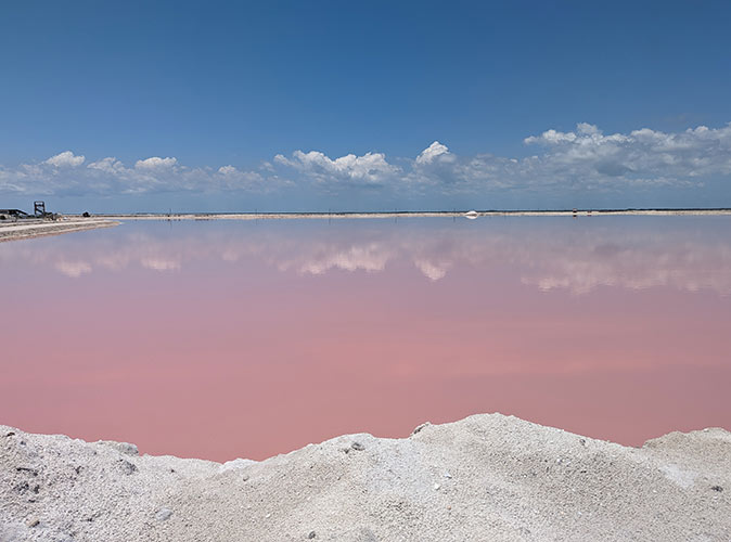A pink colored lagoon and bright blue sky
