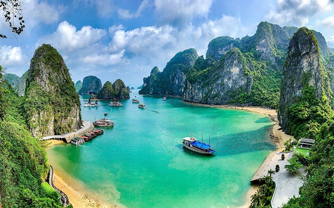 a bay with several boats surrounded by high rock formations