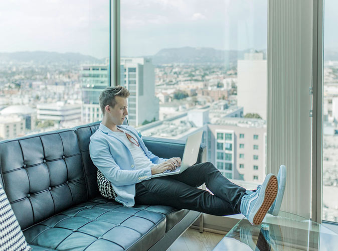 A man working on a laptop on a leather couch