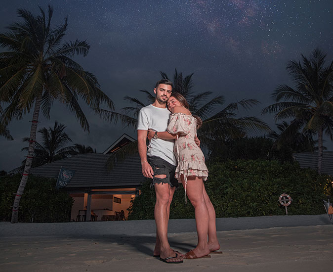 a couple hugging on a tropical beach after sunset