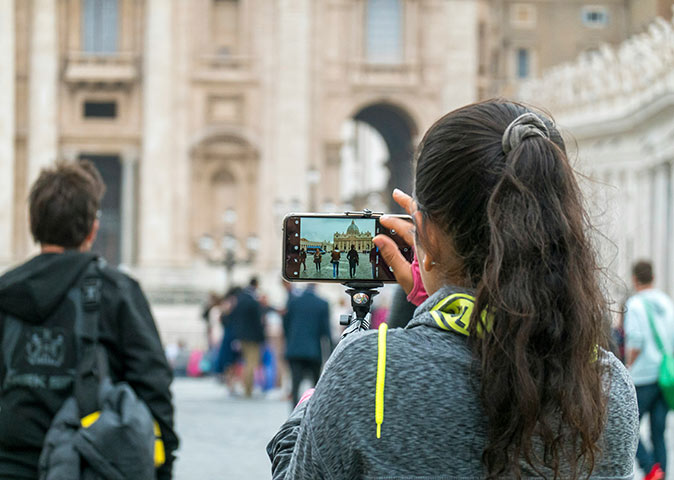 Vatican City dress code A woman holding a phone, taking a picture of the Vatican