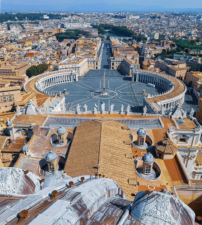 The view from St. Peter's Dome, part of a visit to Vatican City Looking out over a large square surrounded by brown and orange buildings