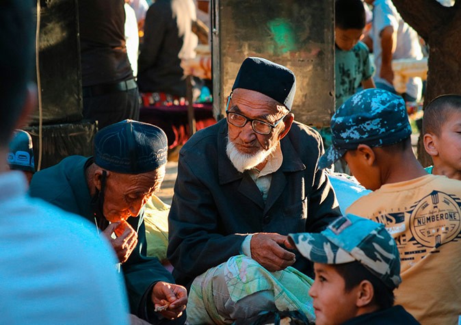 Life in Uzbekistan two older men and several boys sitting outside in Uzbekistan