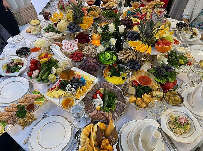 Food at an Uzbek wedding A table filled with a lot of plates of food