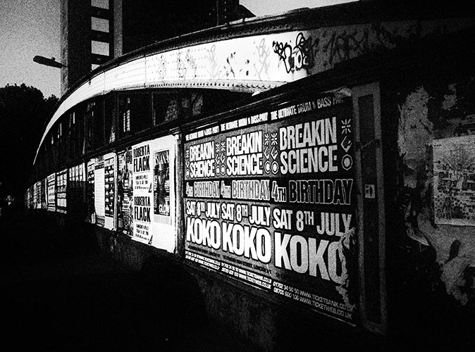 black and white picture of posters ona wall announcing upcoming music events in Camden Town