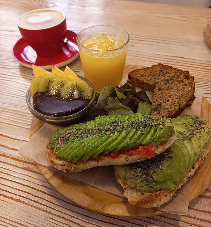 One of many sustainable restaurants in Valencia A vegan brunch consisting of coffee, juice, acai, cake and bread with avocado and tomato