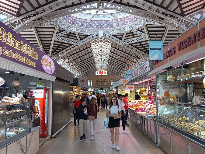 Visit the Mercado Central as an eco-friendly activity in Valencia Several people walking inside an indoor market