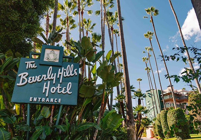 An iconic hotel to visit in LA Palm trees and a sign saying 'Beverly Hills Hotel'