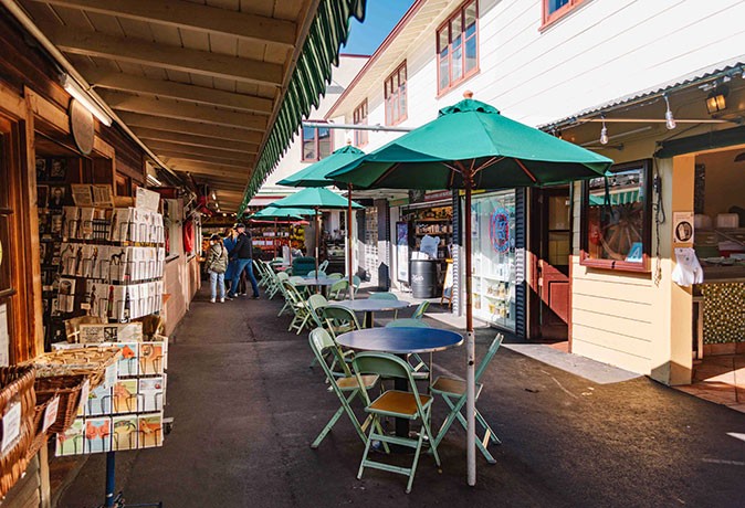Off the beaten path things to do in LA tables, chairs and umbrellas with shops on both sides