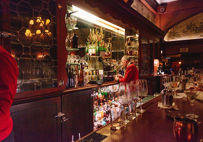 Local tips for where to eat and drink in LA A dark, fancy looking bar with a waiter and several glasses
