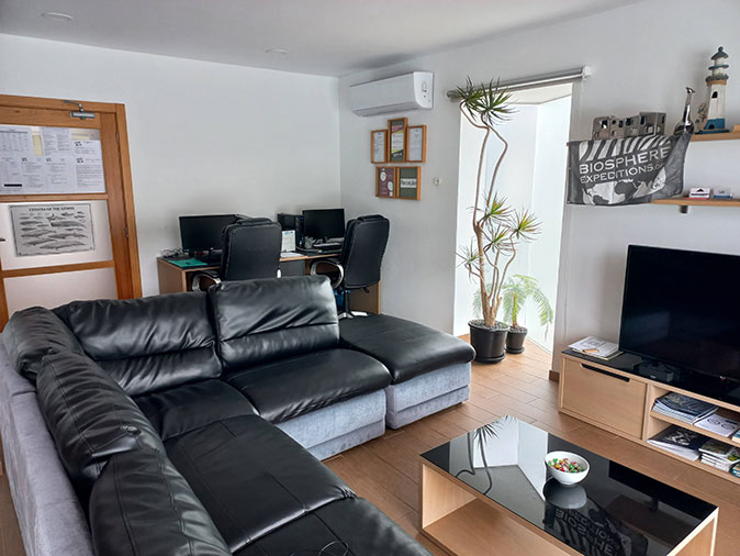 A livingroom with a large, l-shaped black couch and small table