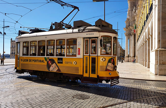 A classic yellow tram with historic buildings in the background
