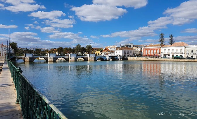 Bridge over a canal with historic buildings in the background