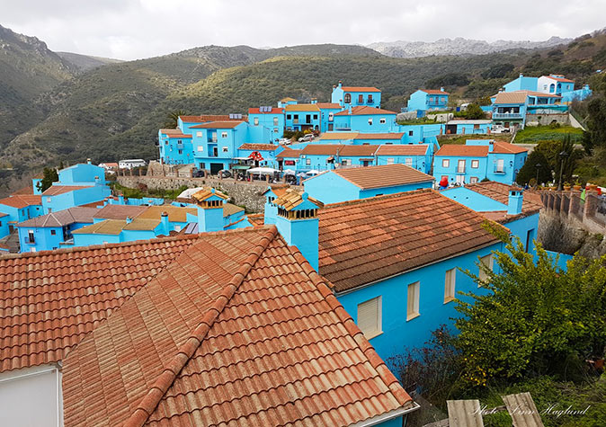 Visiting smurf village with the kids Blue painted houses with mountains in the background
