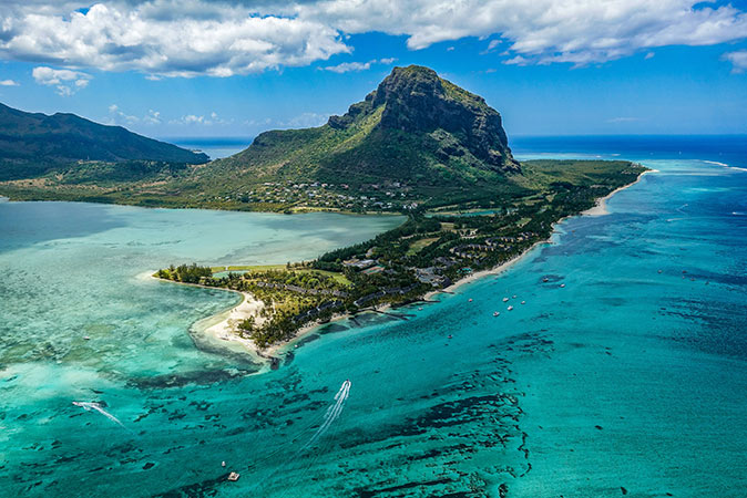 Mauritius, a popular island to move to Aerial view of part of a tropical island, showing blue waters, white sandy beaches and a large green mountain