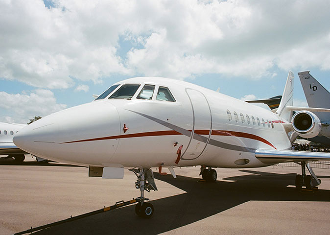 Chartering a jet in Singapore A white private jet with a gray and red stripe on the side