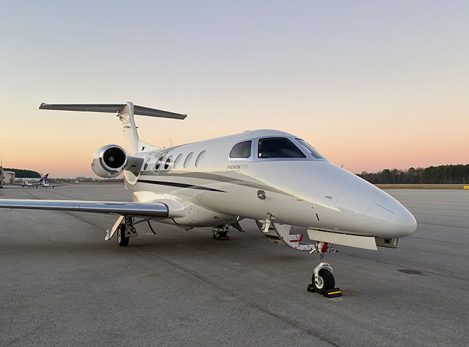 A private jet charter A private jet parked on a runway at sunset