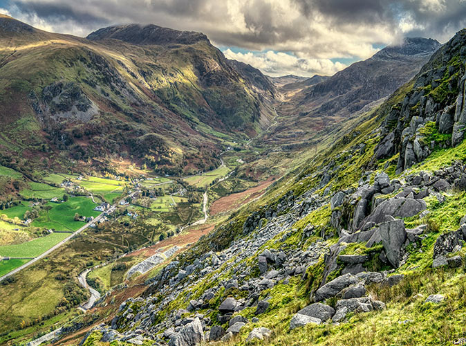 Snowdon hike A valley with a few houses and a lot of greenery, surrounded by high mountains