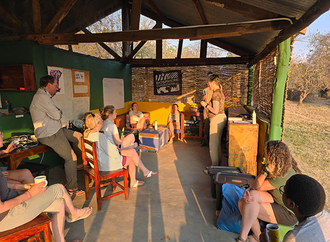 Volunteer work with wildlife conservation in Africa A covered sitting area with various people on chairs and a couch