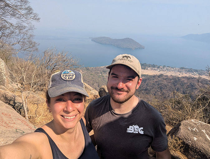 a woman and a man taking a selfie with a large lake in the background