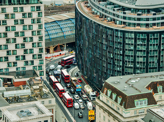 A road with a lot of traffic surrounded by highrise buildings