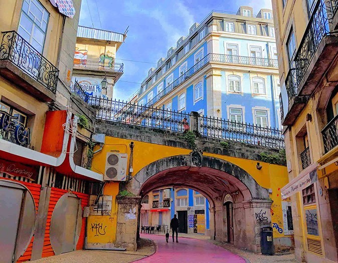 Lisbon, a popular destination for digital nomads in Portugal Colorful buildings and a small, bright yellow historic bridge in Lisbon