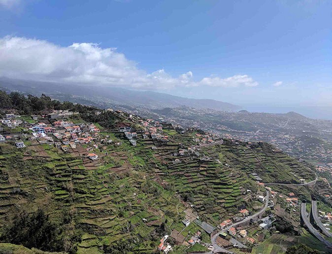Madeira, a top Portuguese digital nomad destination Large green hills with seval houses and roads