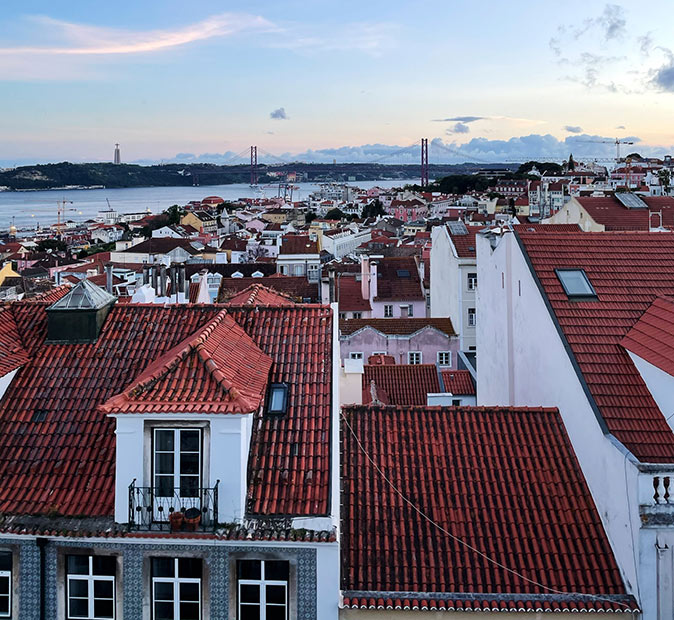 One of the best areas to live in Lisbon Aerial view of a city with a body of water and large bridge in the background