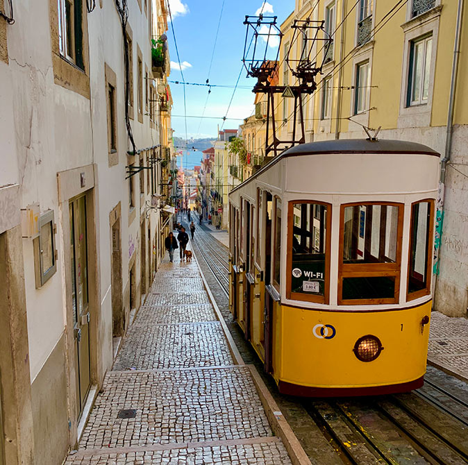 One of the best neighborhoods in Lisbon A steep street with a typical yellow Lisbon tram