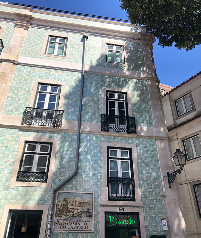One of the best neighborhoods in Lisbon for expats Close-up of a typical Portuguese apartment building with high windows and blue and green tiles
