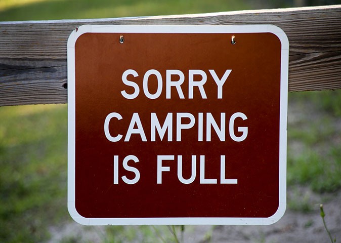 Tips for winter camping in Florida A brown sign with white letters saying 'Sorry Camping is Full'