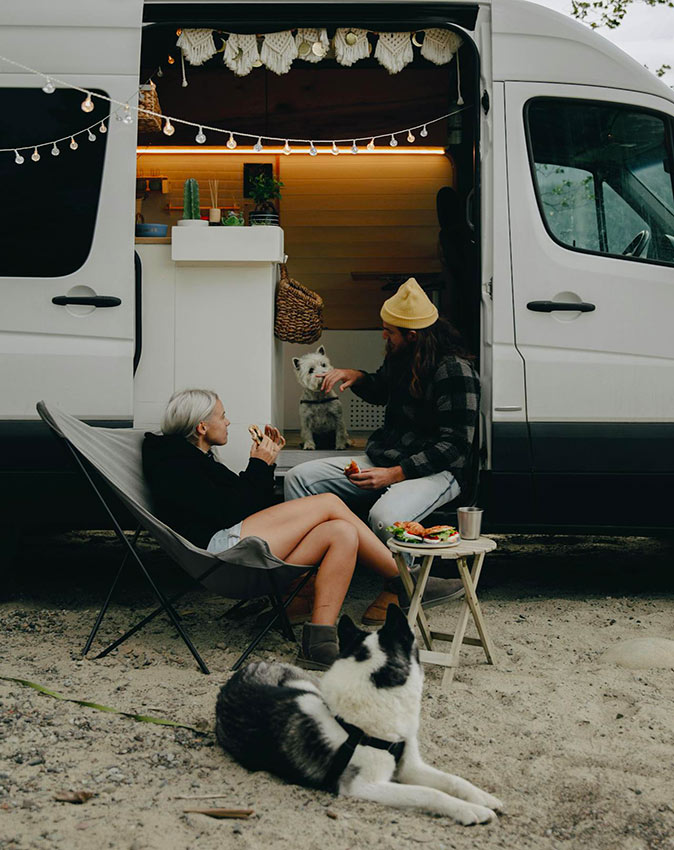 Making the most of winter camping in Florida A couple sitting in front of their small RV with a large black and white dog