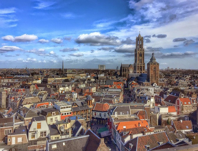 Utrecht, the Netherlands Aerial view of a city with many buildings with brown and orange roofs, and a large brown church