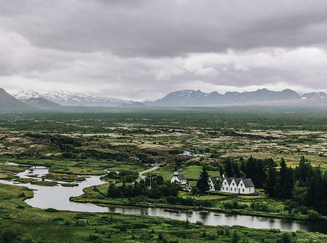 Traveling Iceland by RV Aerial view of a green landscape with a lot of rivers and a few houses