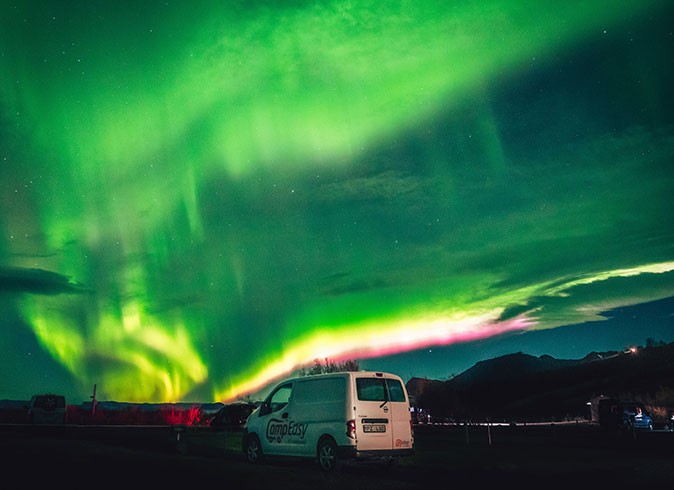 Watching the northern ligths while RVing in Iceland A cmerparvan parked with the northern lights above it