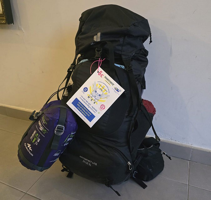 Having your backpack delivered while walking the Camino A large black backpack with a white label on it