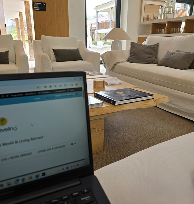 How to work remotely while walking the Camino close-up of a laptop with a brown table and comfortable white couches in the background