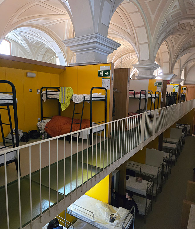 Remote work on the Camino de Santiago 2 floors filled with bunk beds, with a white, arched ceiling
