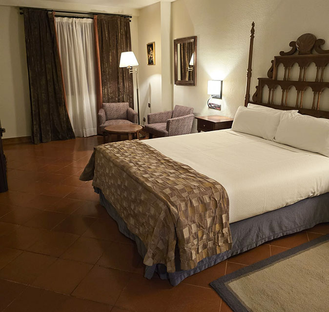 Different types of accommodation on the Camino A spacious hotel room with a traditional brown and white decor
