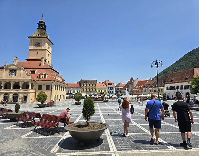 One of the day trips The Better Neighbors organized during the retreat Several people walking on a paved, historic looking square surrounded by old yet well preserved yellow and white buildings with orange and brown roofs