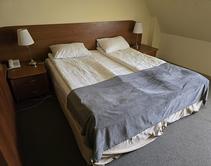 My hotel room during the nomad retreat in Sinaia, Romania 2 single beds in a hotel room with 2 night stands and gray carpet
