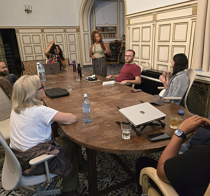 A coworking retreat in Sinaia, Romania A group of people sitting around a large brown table with several laptops