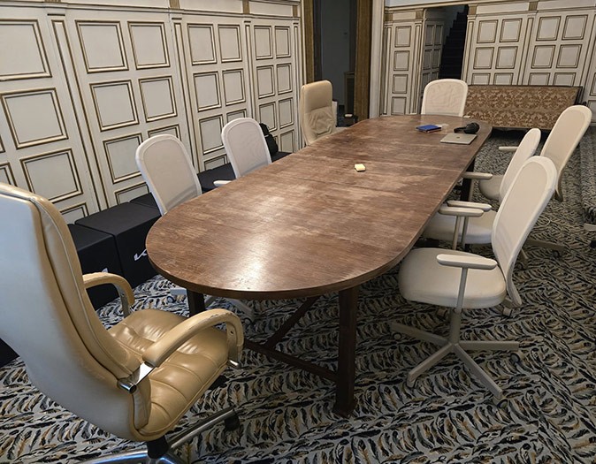 A coworking space inside a historic villa A large brown table with 8 white and brown office chairs around it