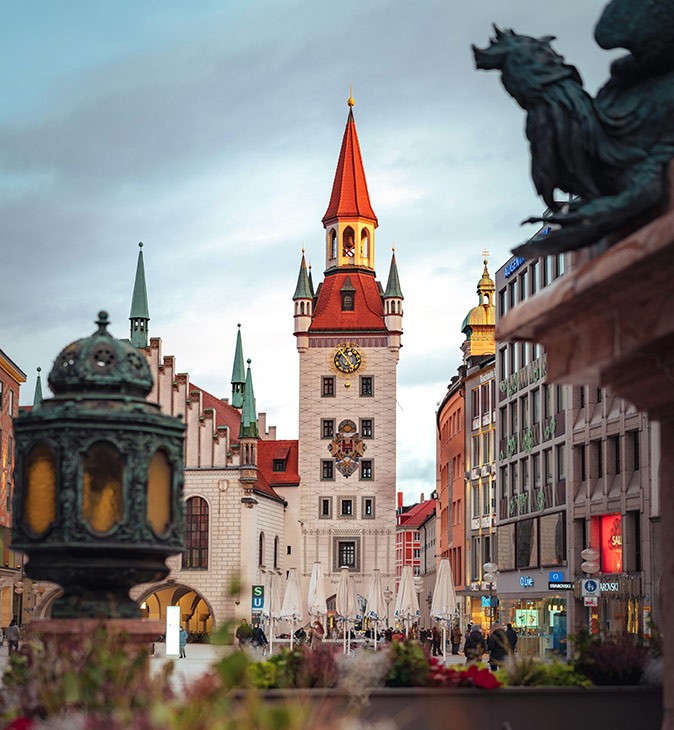 Expat life in Munich Several historic buildings and part of a dark colored statue on a city square