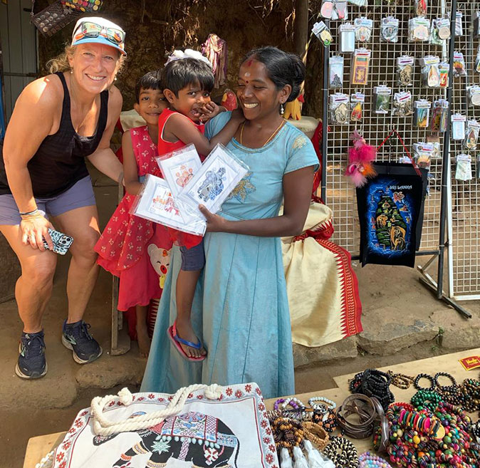 Solo travel as a woman over 50 in Sri Lanka A blond woman posing with Sri Lankan kids selling souvenirs